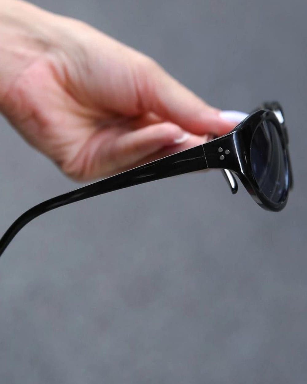 Óculos Noturna oval em acetato preto, segurado pela haste